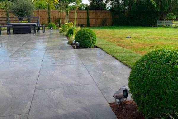 A bespoke patio made from stone paving slabs in a garden.