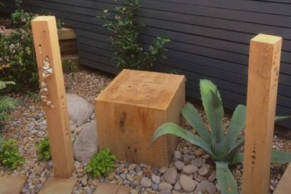 Three wooden sleepers integrated into a garden feature.